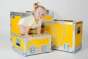 Young child girl between yellow road cases