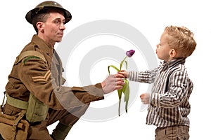 A young child gives a flower to a British soldier photo