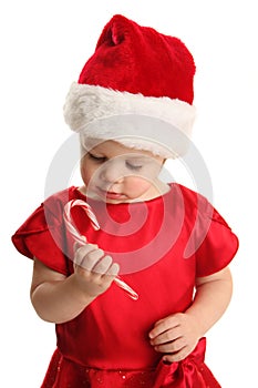 Young child holding and looking at a candy cane