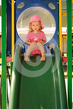 Young child looking sad on a playground slide