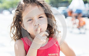 Young child in a red shirt needs silence