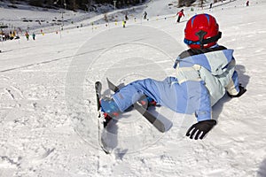 Young Child rests on the edge of a ski slope