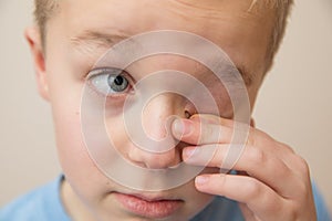 Young child rubbing his eyes with his fingers