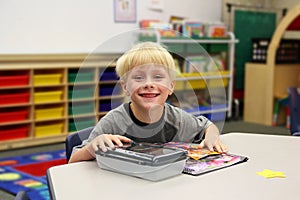 Young Child Sitting at Desk in Kindergarten CLassroom