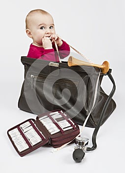 Young child sitting in midwifes case