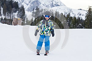 Young child, skiing on snow slope in ski resort in Austria