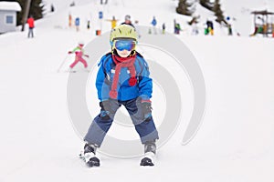 Young child, skiing on snow slope in ski resort in Austria