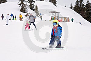 Young child, skiing on snow slope in ski resort in Austria