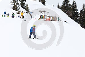 Young child, skiing on snow slope in ski resort in Austria