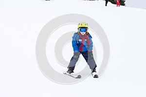 Young child, skiing on snow slope in ski resort in Austria