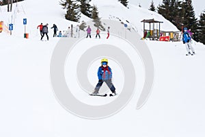 Young child, skiing on snow slope in ski resort in Austria