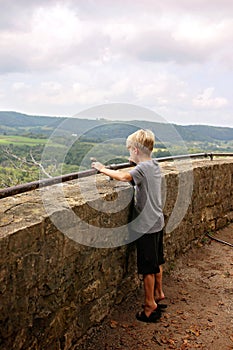 Young Child Standing on Tiptoes Looking over Scenic Overlook Cliff in Midwest America