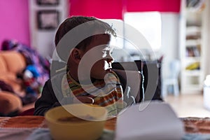 Young child watching TV while eating