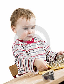 Young child in white background baking cookies