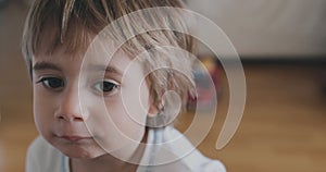 Young child with wide eyes gazing curiously indoors during daytime