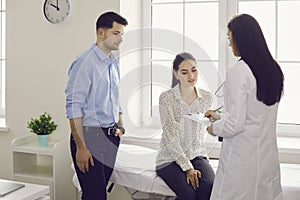 Young childless family couple consulting with doctor getting prescription photo