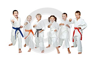 Young children in kimono perform techniques karate on a white background photo
