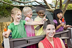 Young children playing in daycare with teacher photo