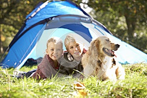 Young children pose outside of tent