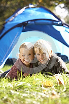 Young children pose outside of tent