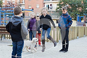 Young children skipping on jumping elastic rope