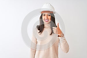 Young chinese architect woman wearing security helmet over isolated white background doing happy thumbs up gesture with hand