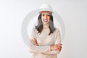 Young chinese architect woman wearing security helmet over isolated white background happy face smiling with crossed arms looking