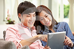Young Chinese Couple Using Digital Tablet