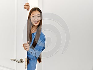 Young chinese girl smiling happy entering at new home