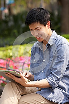 Young Chinese Man Using Digital Tablet