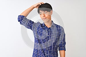 Young chinese man wearing casual blue shirt standing over isolated white background confuse and wonder about question