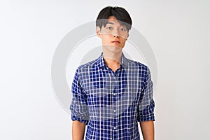 Young chinese man wearing casual blue shirt standing over isolated white background depressed and worry for distress, crying angry