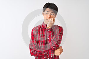 Young chinese man wearing casual red shirt standing over isolated white background looking stressed and nervous with hands on