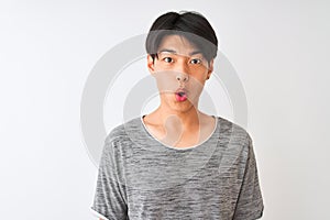 Young chinese man wearing casual t-shirt standing over isolated white background scared in shock with a surprise face, afraid and