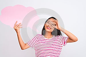 Young chinese woman holding cloud speech bubble standing over isolated white background with happy face smiling doing ok sign with