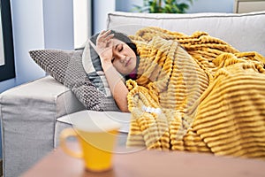 Young chinese woman ilness lying on sofa at home photo