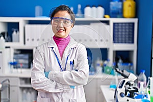 Young chinese woman scientist smiling confident standing with arms crossed gesture at laboratory