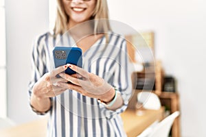 Young chinese woman smiling confident using smartphone at office