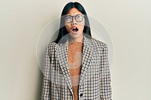 Young chinese woman wearing business style and glasses angry and mad screaming frustrated and furious, shouting with anger