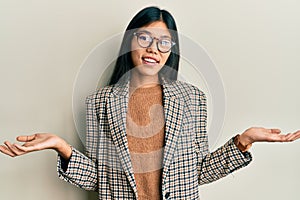 Young chinese woman wearing business style and glasses smiling showing both hands open palms, presenting and advertising