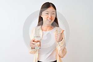 Young chinese woman wearing glasses drinking glass of water over isolated white background happy with big smile doing ok sign,