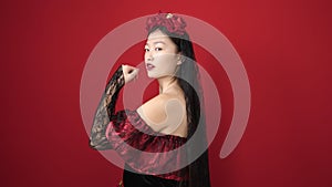 Young chinese woman wearing katrina costume with relaxed expression over isolated red background