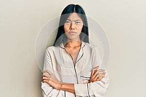 Young chinese woman wearing pajama skeptic and nervous, disapproving expression on face with crossed arms photo