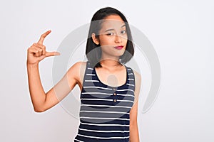 Young chinese woman wearing striped t-shirt standing over isolated white background smiling and confident gesturing with hand