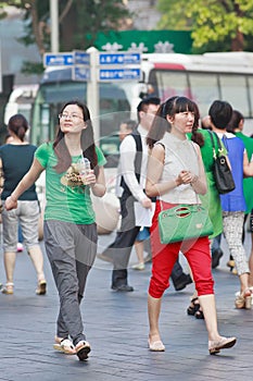 Young Chinese women walk on the street, Shanghai, China