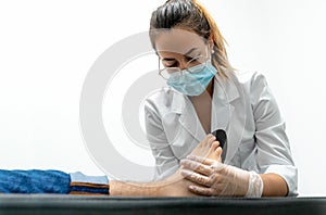 Young chiropodist trying out insoles on a patient. You can see the podiatrist and the patient`s foot on the stretcher