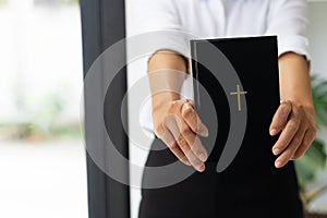 young christian girl holding bible in hand Read the Bible in the house. Concept for Faith,