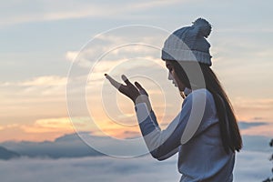 Young christian woman hands open palm up worship and praying to god at sunrise, Christian Religion concept background