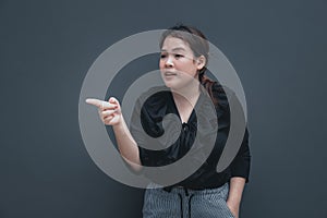 Young chubby asian woman point her finger to the side for asking price and making choice