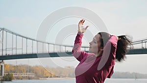 Young chubby girl ties her hair up before morning training routine of running and nordic walking. Sports and Recreation concept